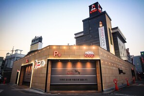 A hotel with a prominent 'HOTEL KANU' sign, a parking sign, and a 'GRAND OPEN' sign indicating a new opening. - Kanu Hotel (Jeonju)