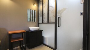 A bathroom with a wooden vanity, a white sink, and a mirror. - Kanu Hotel (Jeonju)