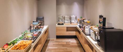 Montaje tipo bufé con diversos alimentos y una máquina de café.