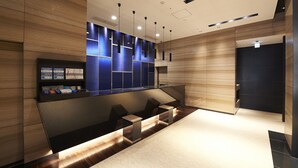 A modern reception area with a wooden panel wall, a reception desk, and a seating area. - Sotetsu Fresa Inn Tokyo-Kanda (Tokyo)
