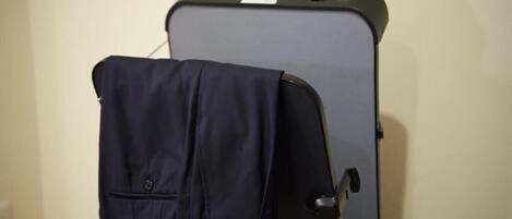 A suitcase with a jacket hanging on the side of a black suitcase.