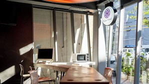 Uma sala de conferência com uma mesa comprida, cadeiras, um computador e uma televisão.