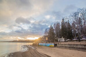 Rannalla, aurinkotuoleja, purjelautailumahdollisuus