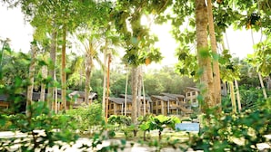 Un complexe hôtelier comprenant plusieurs bungalows en bois, entourés d’une végétation luxuriante et de palmiers.