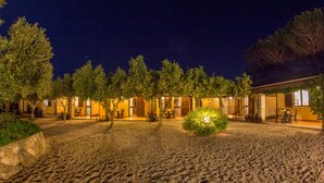 A courtyard with a gravel path, trees, and outdoor seating areas.