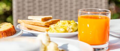 A breakfast setting with toast, scrambled eggs, and orange juice on a table.