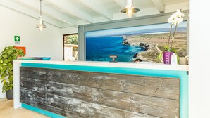 A reception desk with a wooden panel design, a view of the ocean, and a sign indicating a medical facility.