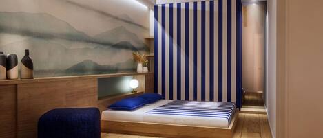 Quarto moderno com piso de madeira, cama com roupa de cama azul, mesa de cabeceira, luminária na parede e cortina listrada.
