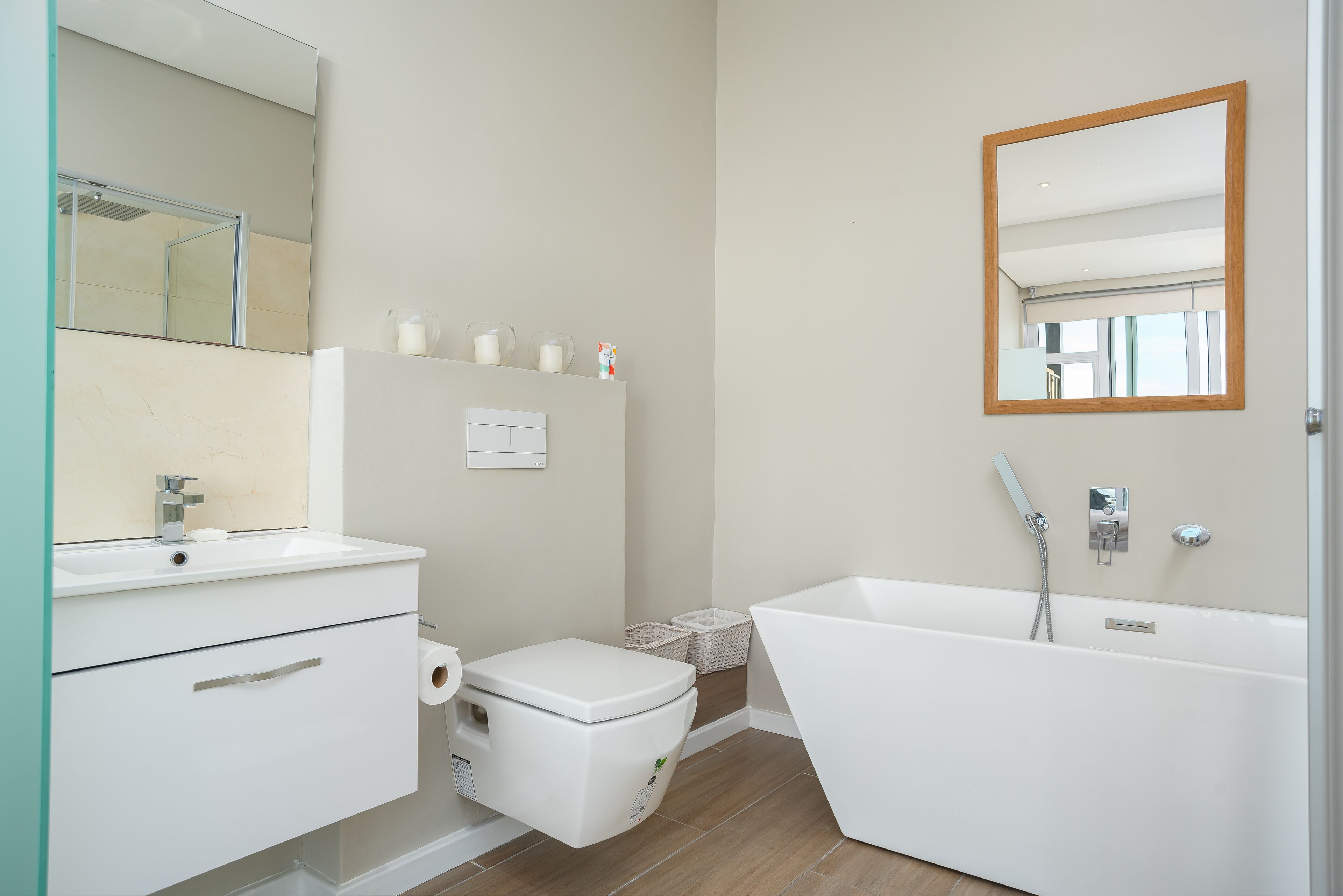 Un baño moderno con lavamanos, inodoro y bañera blancos.