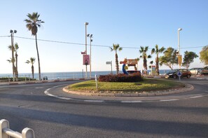 Una rotonda con palmeras, un cartel que dice 'Shanti' y vista al mar.
