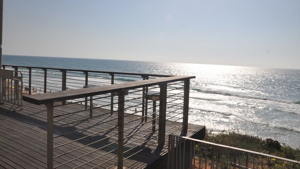 A wooden deck with a railing overlooking the ocean. - Isra Home Apartments Ben Gurion 81 (Bat Yam)