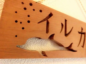 Un letrero de madera con la silueta de un pez y caracteres japoneses.