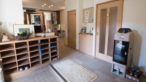 Hotellihuone, jossa on kenkäteline, juomavesiautomaatti ja pieni matto.