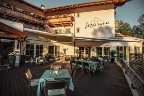 A hotel patio with outdoor seating, large windows, and a sign reading "Hotel Marica." - Hotel Marica (Nova Ponente)