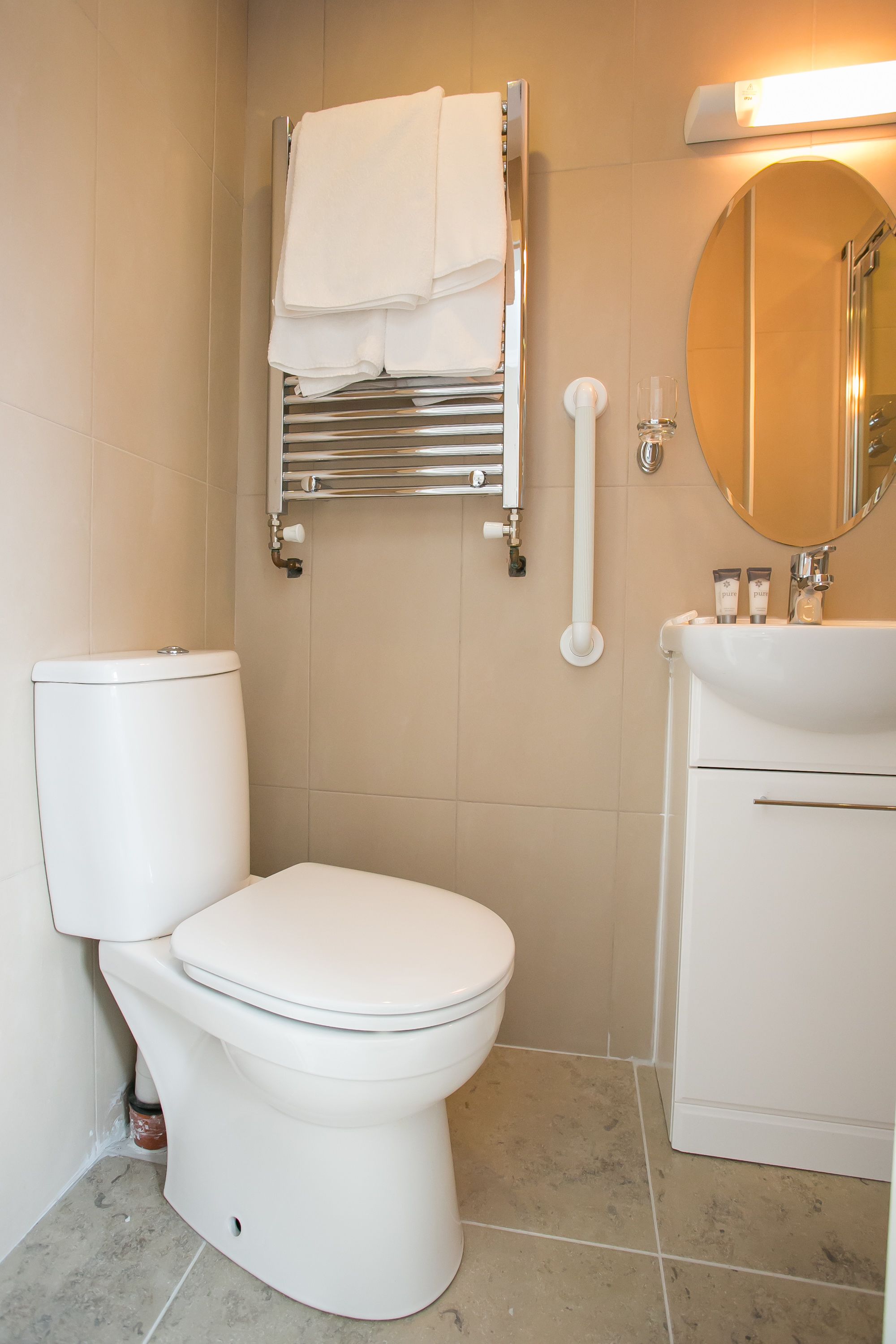 A modern bathroom with a white toilet, a sink, and a mirror.