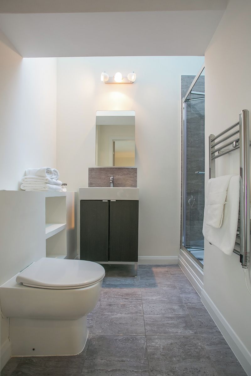 A modern bathroom with a toilet, sink, and shower.