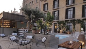 An outdoor patio with seating, a pool, and a bar area. - Hotel Oasis (Barcelona)