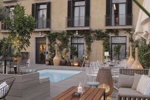 A rooftop pool area with outdoor seating and potted plants. - Hotel Oasis (Barcelona)