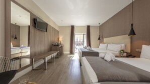 A hotel room with two beds, a desk, a chair, a TV, and a large window. - Hotel Oasis (Barcelona)