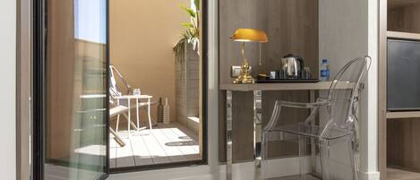 A modern kitchen with a glass partition, a yellow lamp, and a refrigerator.