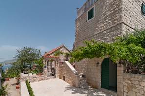Un edificio de piedra con una puerta verde y una escalera que conduce a un pequeño porche.