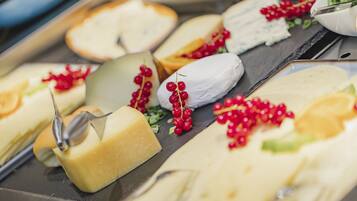 A variety of cheeses and fruits on a tray.