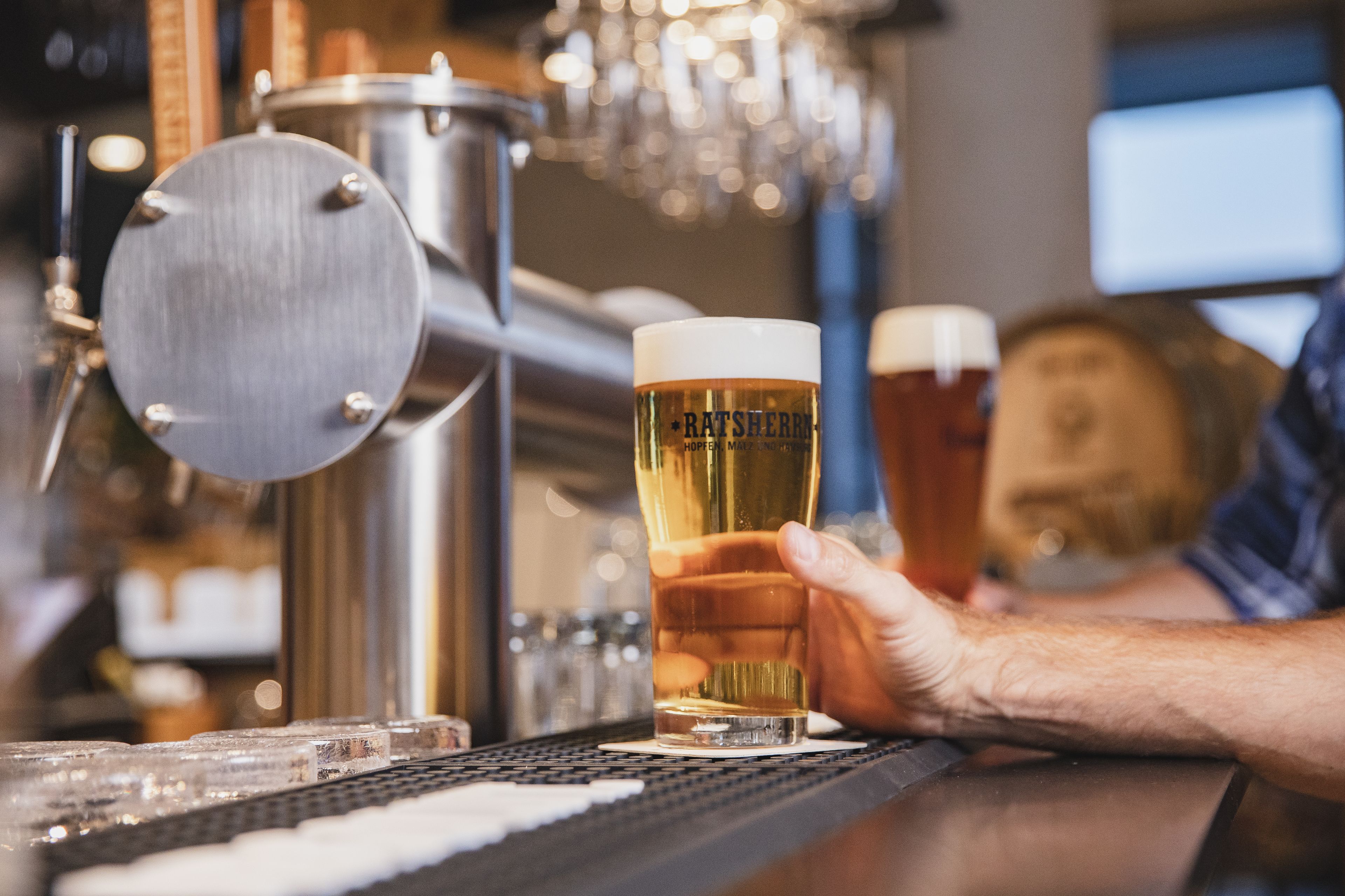 A bartender pouring beer into a glass at a bar.