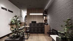 A modern hotel lobby with a reception desk, seating area, and a sign reading "HOTEL TRANSIT". - Hotel Transit (Barcelona)