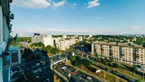 A cityscape with high-rise buildings, a busy road, and a clear sky.