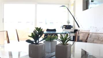 A dining table with three potted plants in the center.