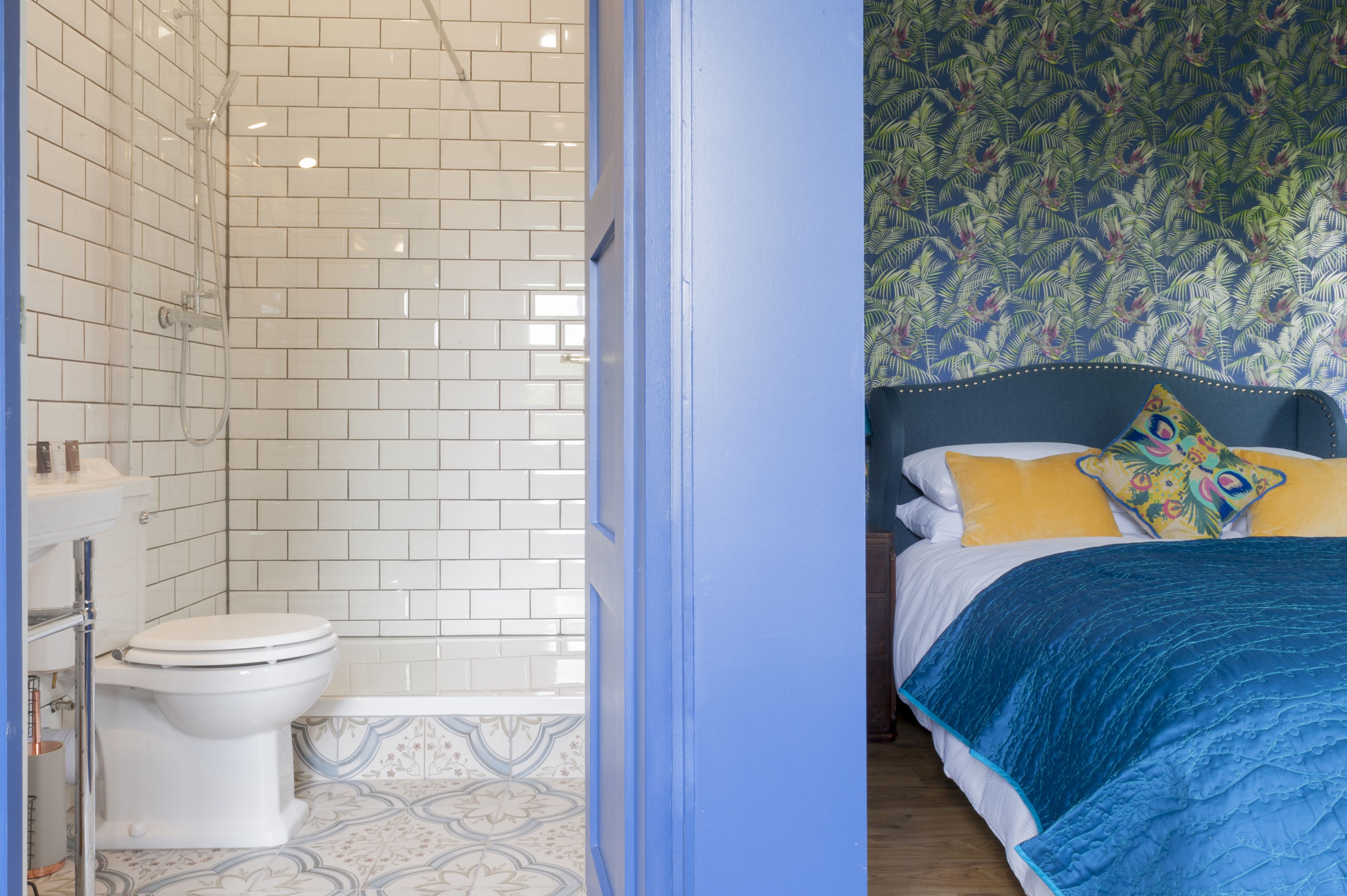 A bathroom with white tiled walls and a toilet.
