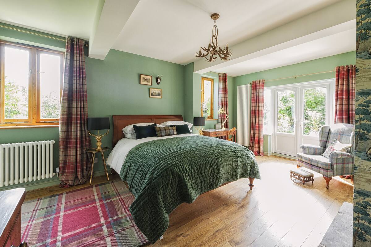 A bedroom with a bed, a chair, a radiator, and a window.