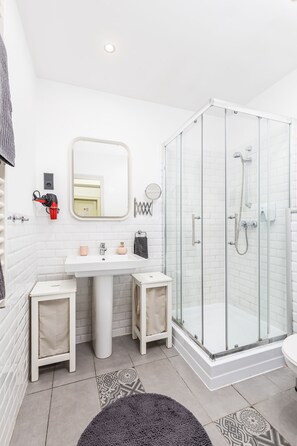 Luxe appartement | Badkamer | Een haardroger, handdoeken, zeep, shampoo