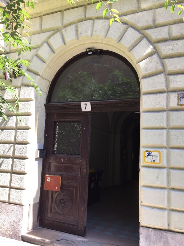 An arched entrance with a number 7 sign, a door with a keypad, and a small sign indicating a 2.35 price point.