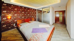 Une chambre à coucher avec un lit, un papier peint à motifs floraux, un plancher en bois et une porte coulissante.