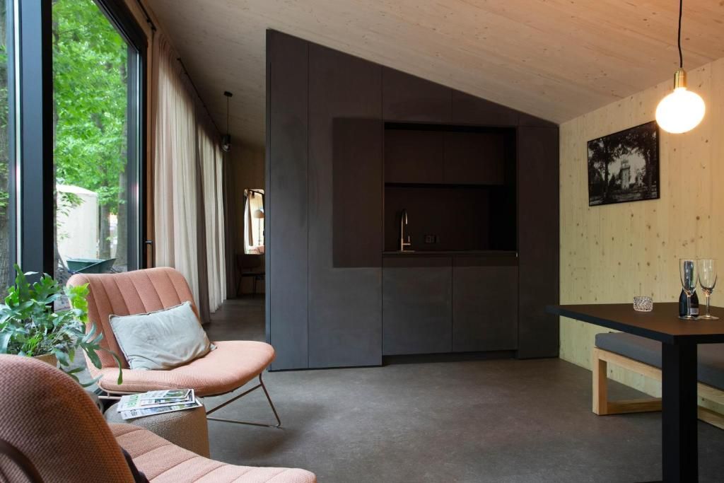 A modern interior with a seating area, a built-in kitchen, and a dining table.