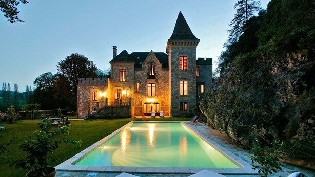 A stone castle with a swimming pool and lounge chairs. - Manoir de la Malartrie (Vezac)