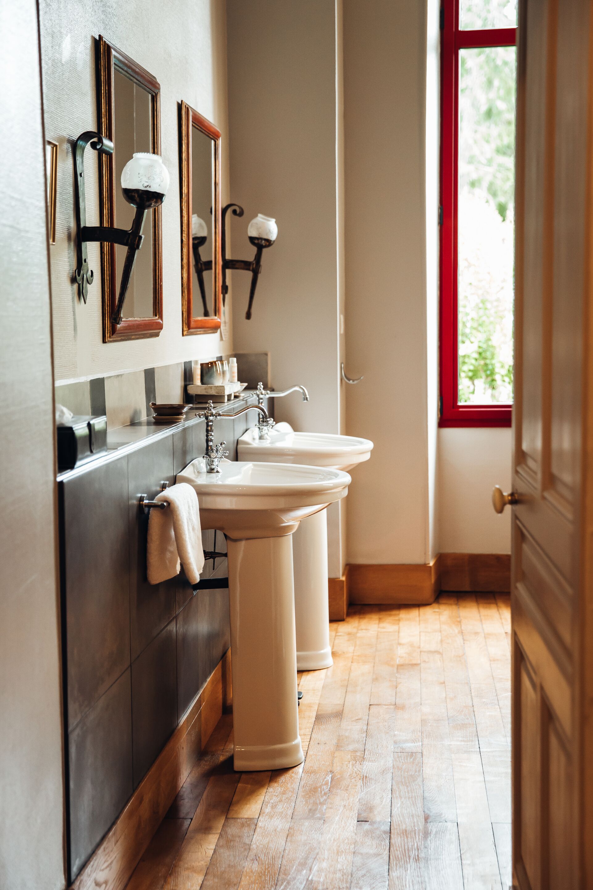 A bathroom with two sinks, a mirror, and a window.