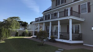 A two-story house with a covered porch and a small garden. - Rooms in Family House in Salem Boston (Saugus)