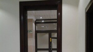 A hallway with a wooden door frame, a sign indicating an exit, and a tiled floor. - Channel View Lodge (Kempton Park)