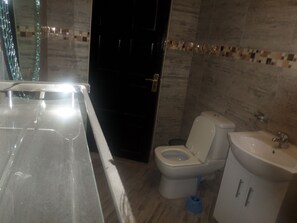 Une salle de bain avec une baignoire, des toilettes et un lavabo.