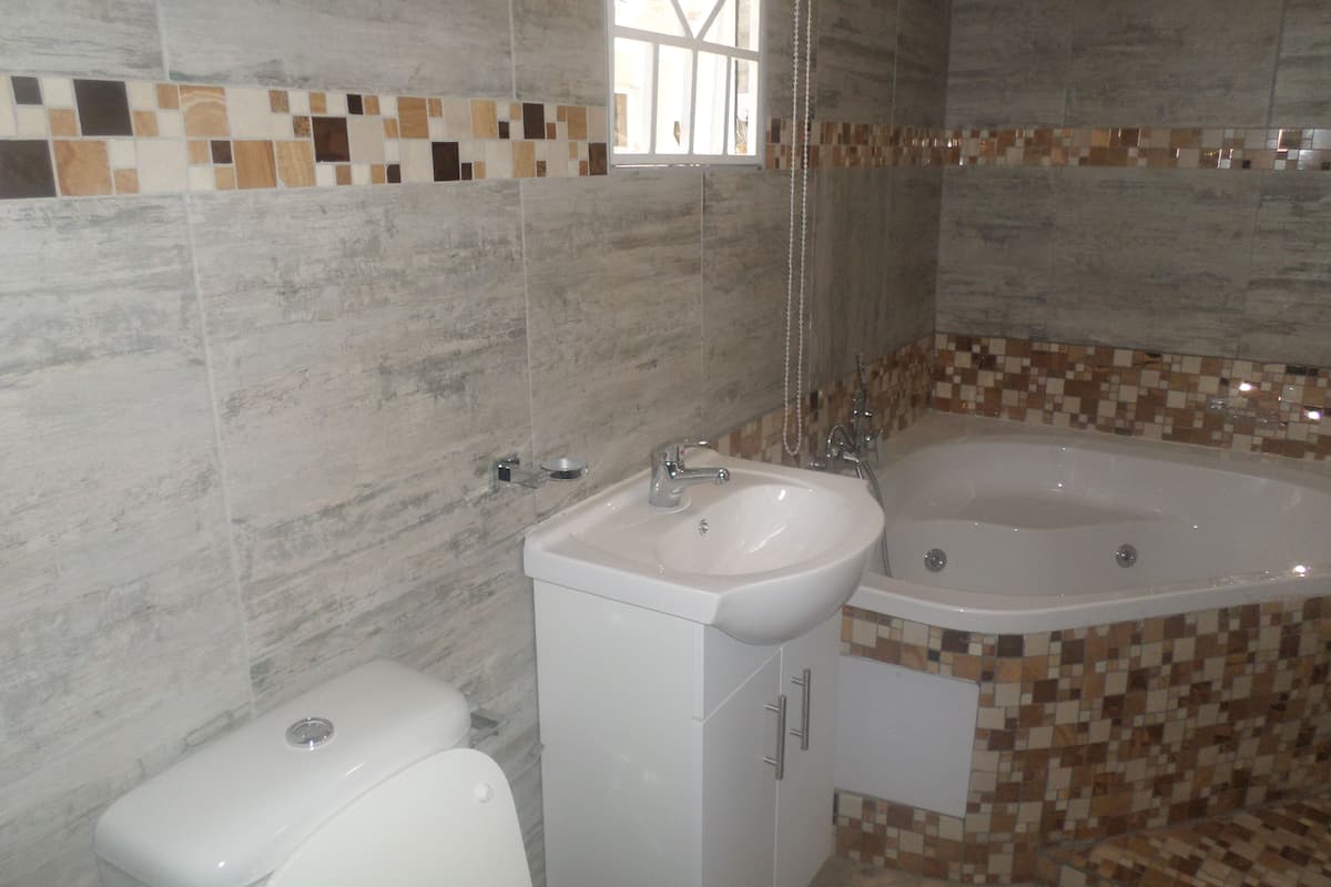 deluxe double room, jetted tub | bathroom | shower, free toiletries, towels