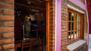 A rustic wooden interior with a brick wall and a window with a wooden frame.