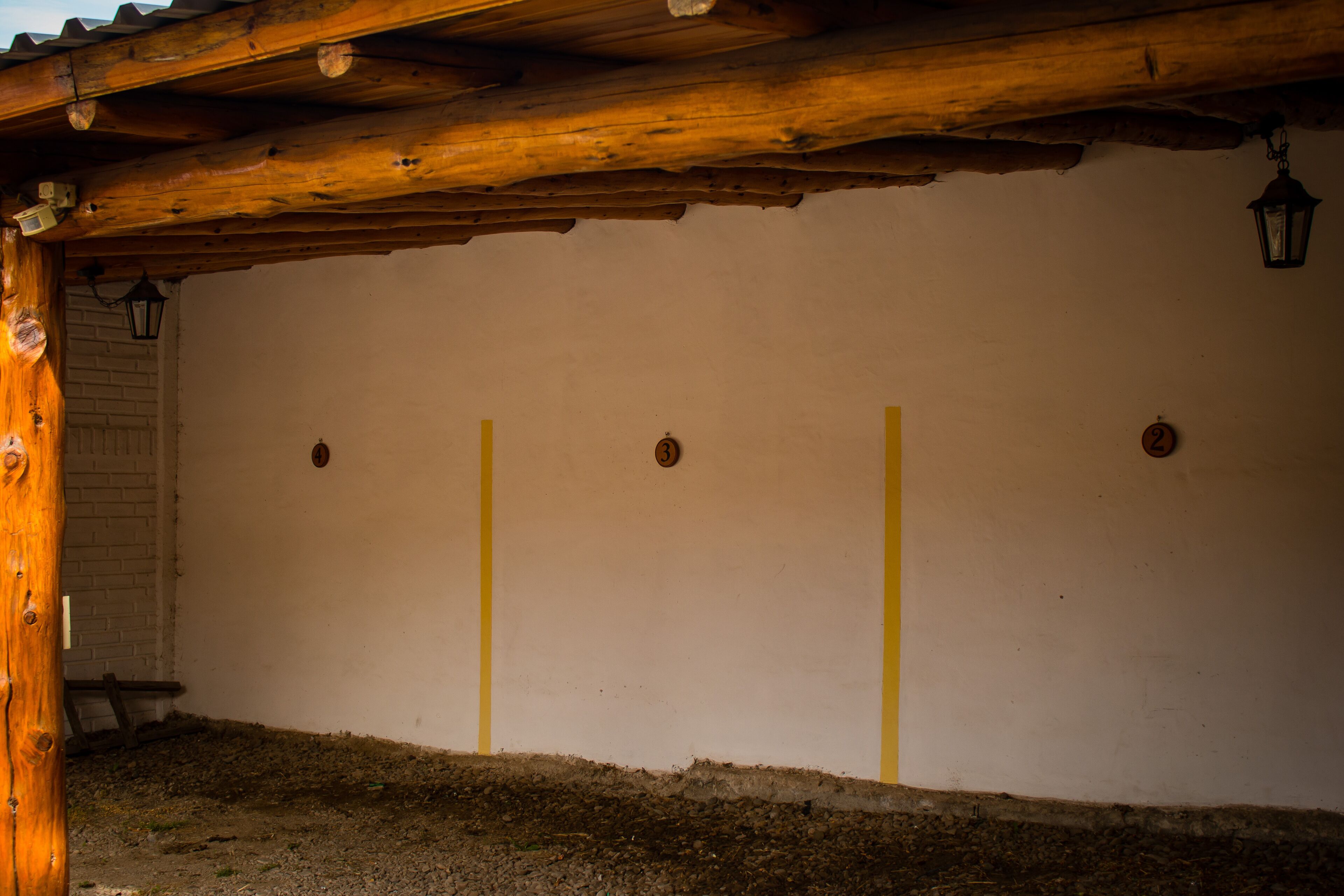 A rustic wooden structure with a white wall and three yellow vertical lines.