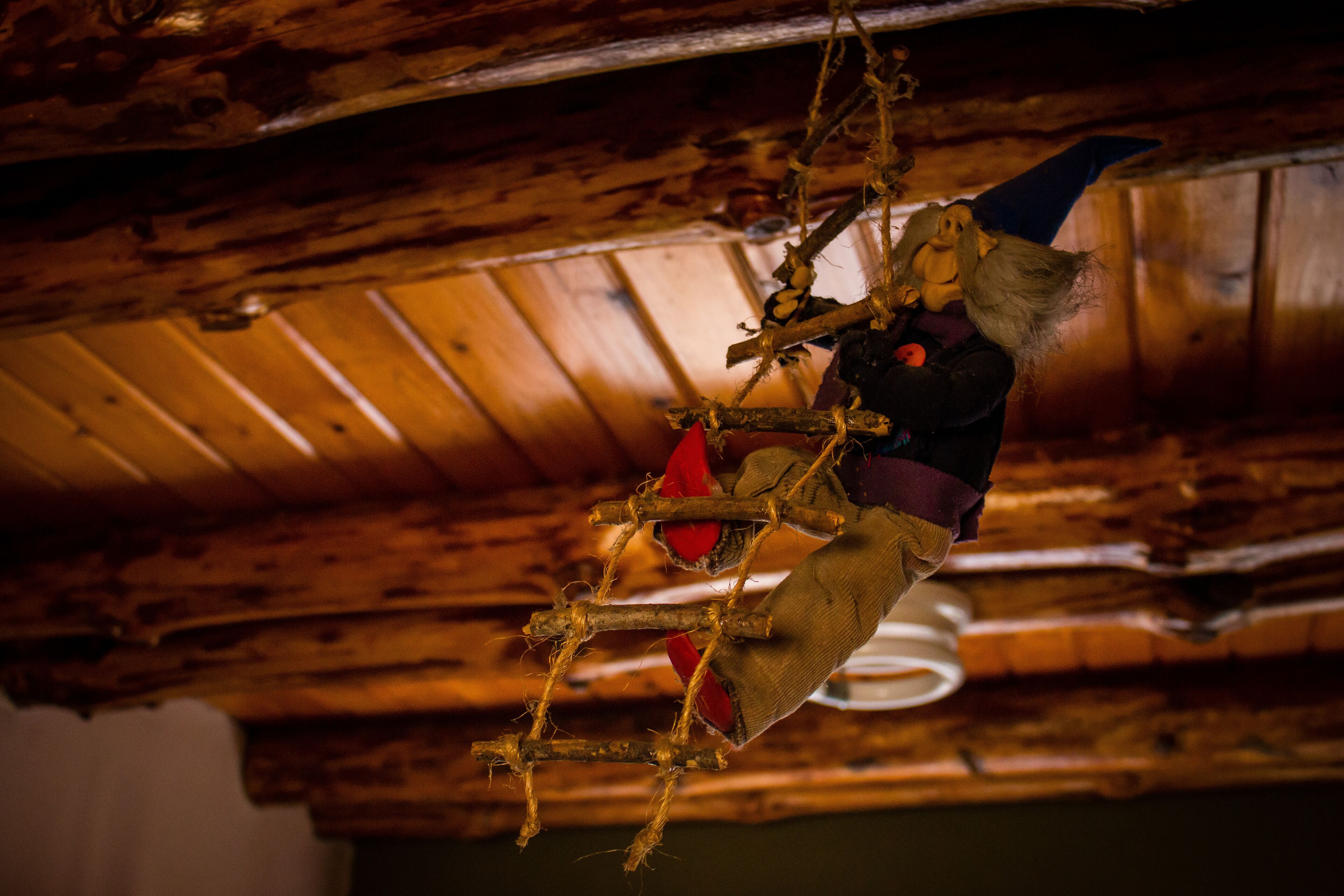 A rustic wooden ceiling with exposed beams and a hanging decoration.