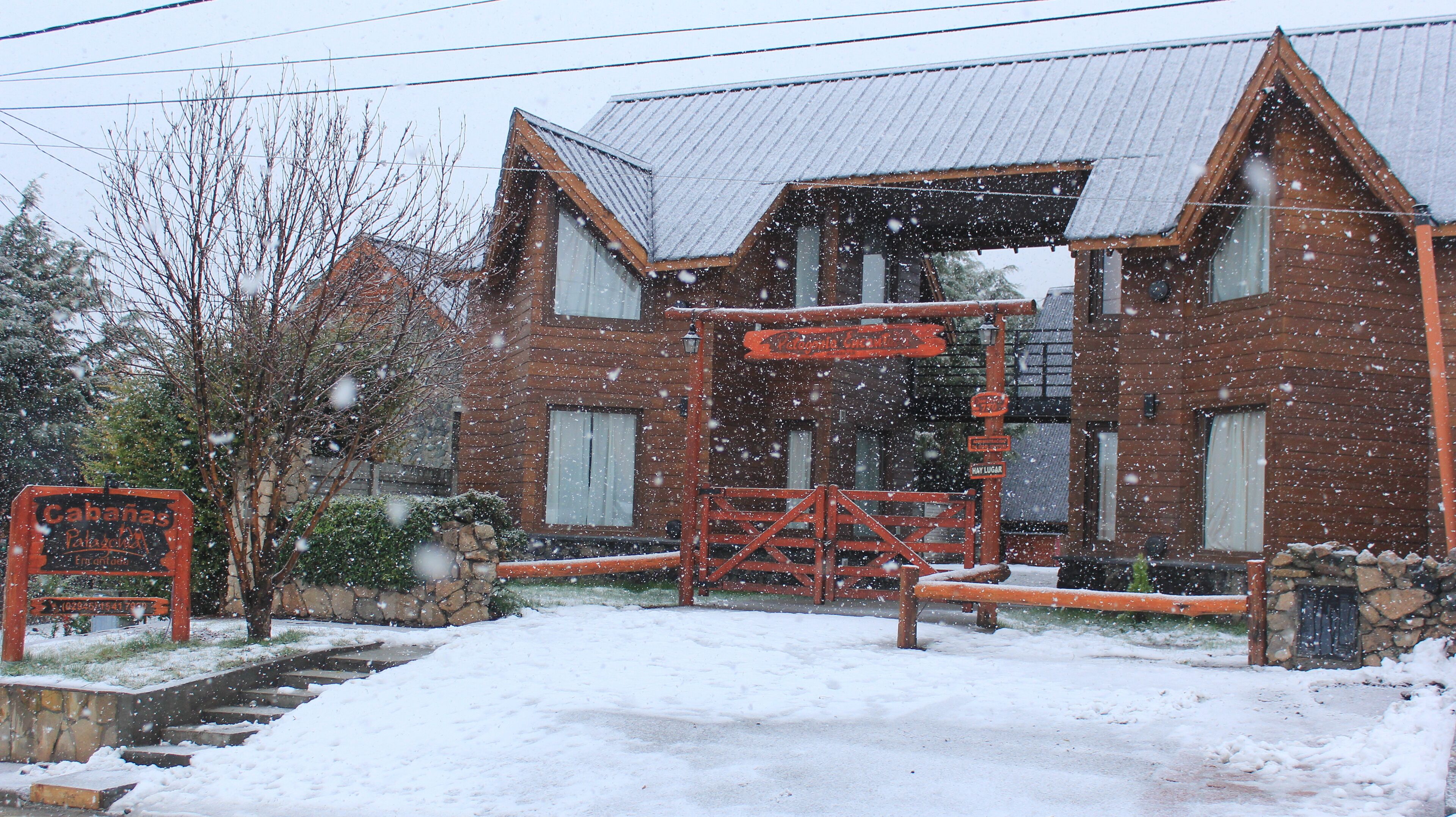 A wooden building with a metal roof, surrounded by snow.