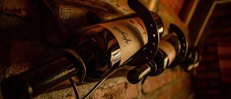 A wine bottle with a label on a brick wall.