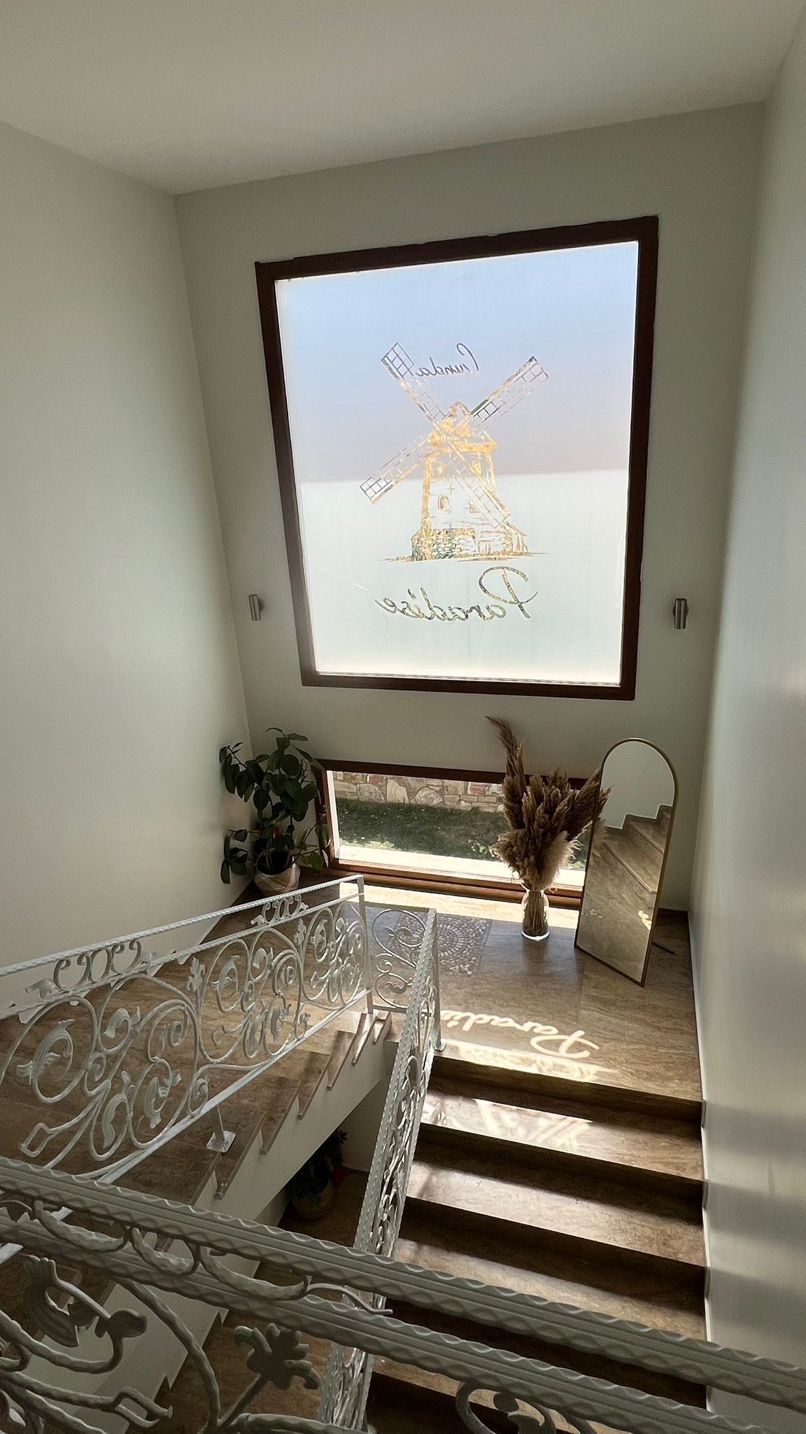 Una escalera con vistas a un molino de viento a través de una ventana.