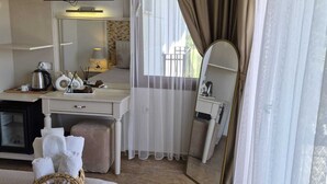 A hotel room with a bed, a desk, a television, a mirror, and a window with curtains. - Cunda Paradise Otel (Ayvalik)