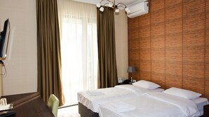 Habitación de hotel con dos camas, un escritorio y una silla.